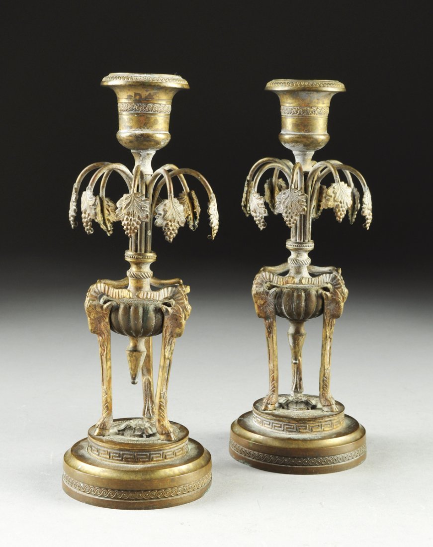 Pair Of Directoire Bronze Candlesticks, 18th C.: Nice pair of French Directoire gilt and silvered bronze candlesticks, circa late 18th century, original (worn) patina. Each being of tripod form with a tapering lobed bowl supported by rams head on re