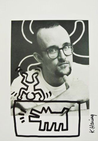 Keith Haring (1958-1990) Felt Pen Drawing: Black felt-tip pen drawing on printed page (with photograph of Keith Haring), by/attributed to Keith Haring (1958-1990). Signed. 11 7/8 x 8 1/2 inches. Very good condition. Small hinge remnants on rev