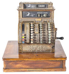 National Cash Register Model 420: Cash register model 420. Serial # S310499G. Embossed brass register resting on oak base with a drawer. 20 1/2w x 40 1/4d x 21h.