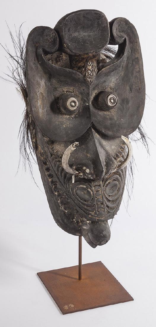 19th Century African Mask: Carved mark on stand with applied antique shells and fossils. Applied hair to verso. Circa 1880. Stand was made later. Size (mask only) 10 1/2w x 9d x 20 1/2h