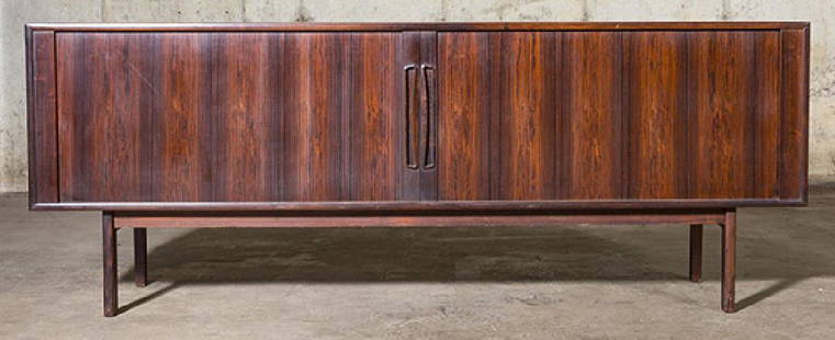 Poul Norreklit Credenza: Outstanding credenza. Denmark. Georg Petersens. 1960. Rosewood. Rare wood legs. Tambour doors concealing shelves and four drawers. Label to verso. Size 78 3/4w x 19d x 30 1/2h.