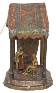 Austrian Cold Painted Cast Metal Lamp: Metal lamp depicting a man and lady figure with fancy canopy and ornate accents. Working condition. Stamped on underside. 6 1/2w x 5 1/4d x 10 1/4h.