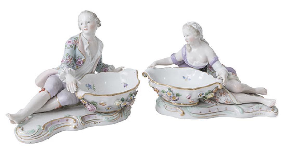 Pair of Meissen Figural Sats: Dishes. 20th Century. Models 2872 and 2875. Couple reclining with oval dishes. Blue crossword mark and incised numbers 2872/163/28 and 2875/163/137 to underside. Chips to flowers. 6 1/2w x 5d x 4 1/2h