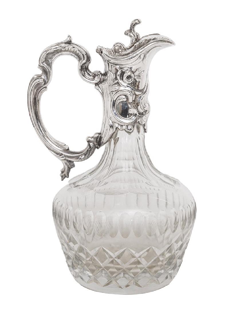 Cut Glass & Silver Plate Wine Server: Cut glass bond with ornate ornate silver plate fitted top with embossed flowers, scrolls, and acanthus leaves. Large, ornate "C" handle. Not marked. Not monogrammed. 5 1/2 dia x 10 1/2h.