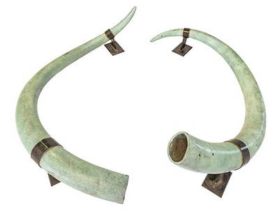 Outstanding Bronze Tusks: 20th century pair of bronze tusks with applied variegated patina. Bronzed patina steel wall mounting brackets. 63w x 13 1/2d x 33h.