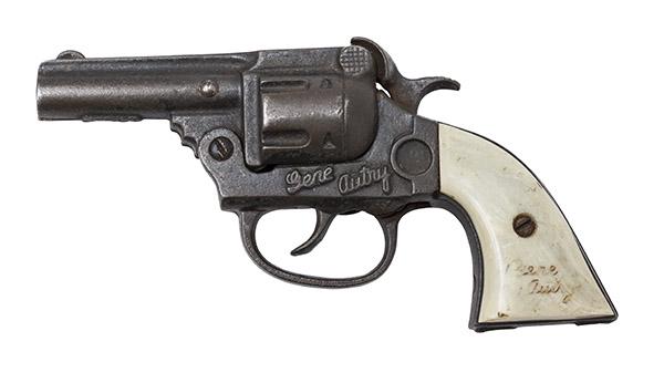Kenton Toys Cast Iron Gene Autry Cup Cap Gun: The famous cowboy cap gun. All original with peal grips. 6 1/2w x 1 5/8d x 3 1/2h.