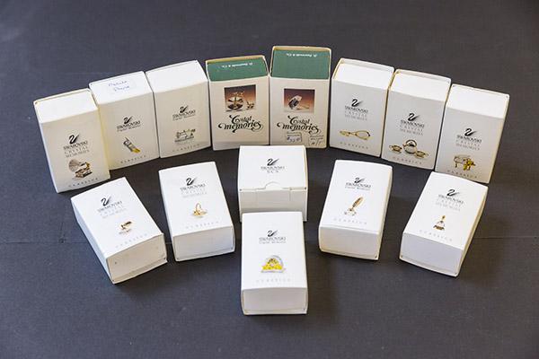 Assembled Swarovski Crystal Memories in Original Box: Miniature crystal and gold plated objects. Sewing machine swan, cell phone, dinner bell, trycycle, tennis racket, umbrella, piano, victrolla, basket, perfume bottle, feather pen and ink well, present