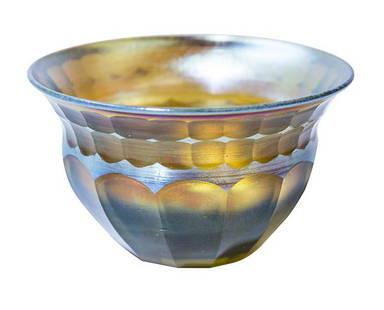Signed LCT Tiffany Favrile Bowl: Bluish, gold iridescent signed L.C.T. Tiffany Favrile small bowl. Paneled cut design with flared rim. 4"W x 2 1/2"H x Base 1 3/4"