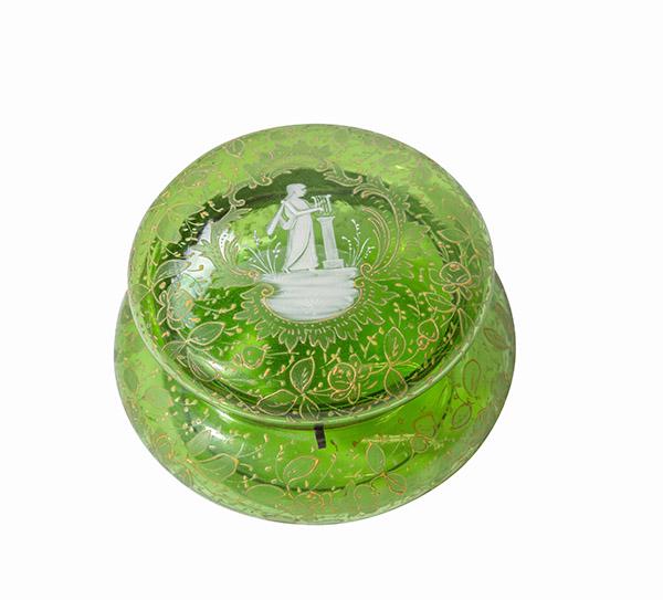 Green Moser Powder Jar: A Moser Mary Gregory Enameled hinged box. Round hinged cover consists of green glass with enamel decoration of a white figure of a woman playing a harp and gold floral scrolling designs. Unmarked. 6 "