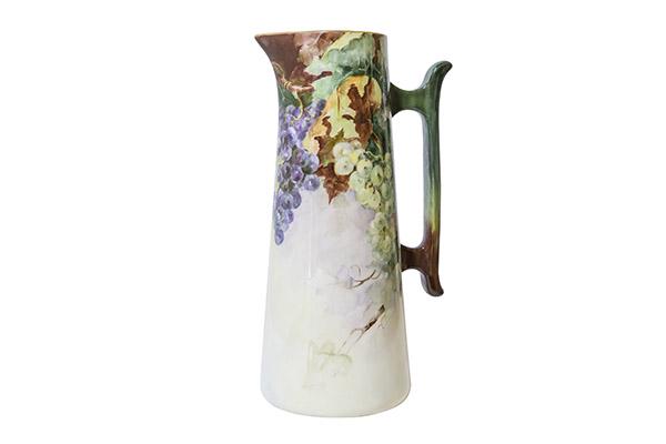 Willets, Belleek Porcelain Tankard With Grapes: Hand painted porcelain pitcher decorated with grape and leaf design. Brown and green porcelain handle with gilt around the rim. Artist signed and dated F. Kaiser 1907. 6 1/2" W x 15" H