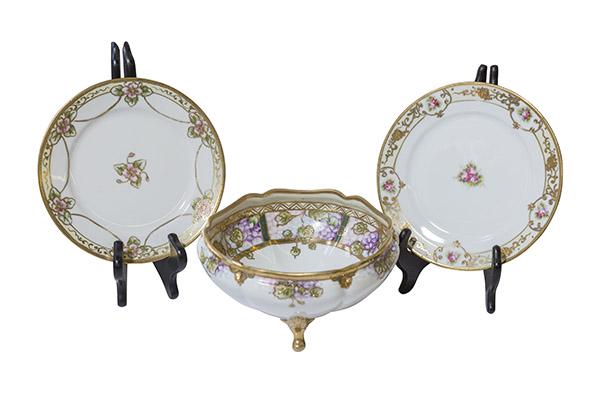 Violet Decorated Nippon Bowl and Plates with Roses: Two Nippon items include; Three footed bowl with violets and heavy gilding. Gold beading along the gilding and delicate detailing. RC Hand Painted Nippon Mark. 7" Dia x 4" H. Two Nippon plates decorat