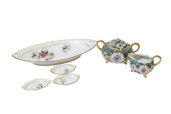 Nippon Cream, Sugar, Celery and Salts Marked: (1) Scrolled footed Cream and Sugar with gold handles, heavy gilding, floral design on green background. 6 1/2"W x 4" H. (1) Nippon Celery and six matching salts with open handles, roses outlined with