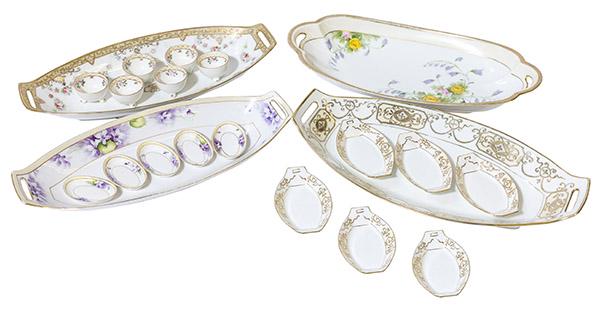 4 Hand Painted Nippon Celery Sets: One Celery dish and three complete Celery Sets hand painted by Nippon. The dish has yellow roses and pink flowers, (1) first set has drapes of roses with gilded design 6 salts with 3 feet. (1) Violet 