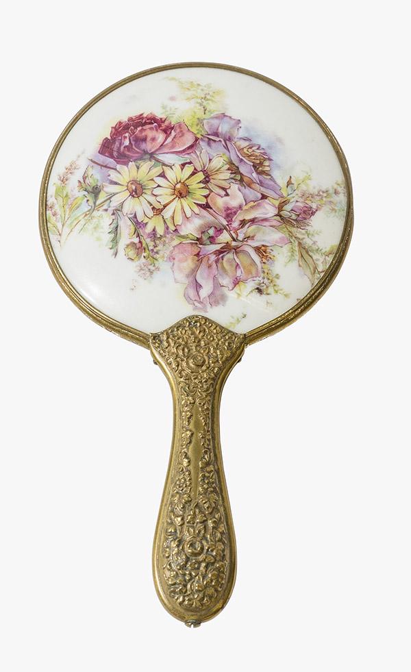Porcelain Limoges Hand Painted Hand Mirror: 1900's Antique Art Nouveau Hand Mirror, hand painted floral bouquet on porcelain back with brass embossed handle and frame with beveled mirror. 5" W x 9 1/2" L.