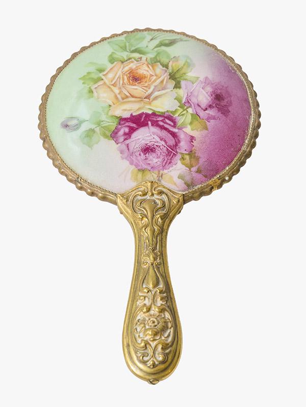 Porcelain Limoges Hand Painted Hand Mirror: Victorian Limoges hand painted hand mirror with three large roses. Brass floral embossed handle and beveled mirror. 5 1/4" W x 9 1/2" L