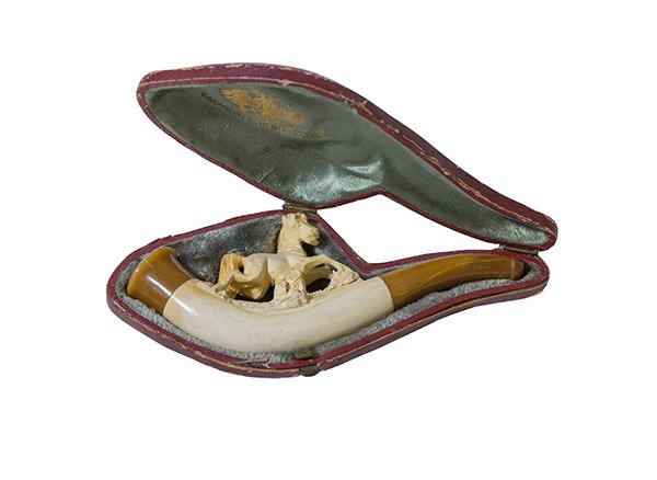 Carved Meerschaum Pipe, Austrian: Carved Meerschaum pipe with bowl carved with a horse in its original leather case. The stem and tip of pipe are amber in color. The case is marked with manufactures mark on the inside cloth lining.