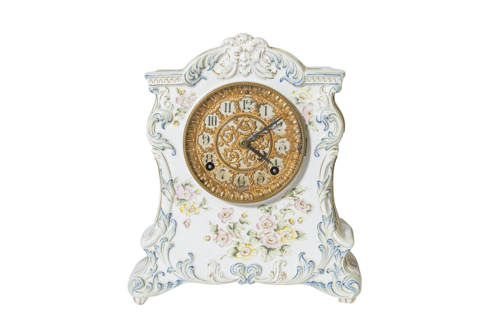 Ansonia Kennebec Porcelain Mantel Clock: Porcelain case with scrolled feet with embossed scrolled acanthus leaves and Man in the Mountain Face below center pediment. Decorated with flower motif, gilded in blue accents. Original gilded ornate