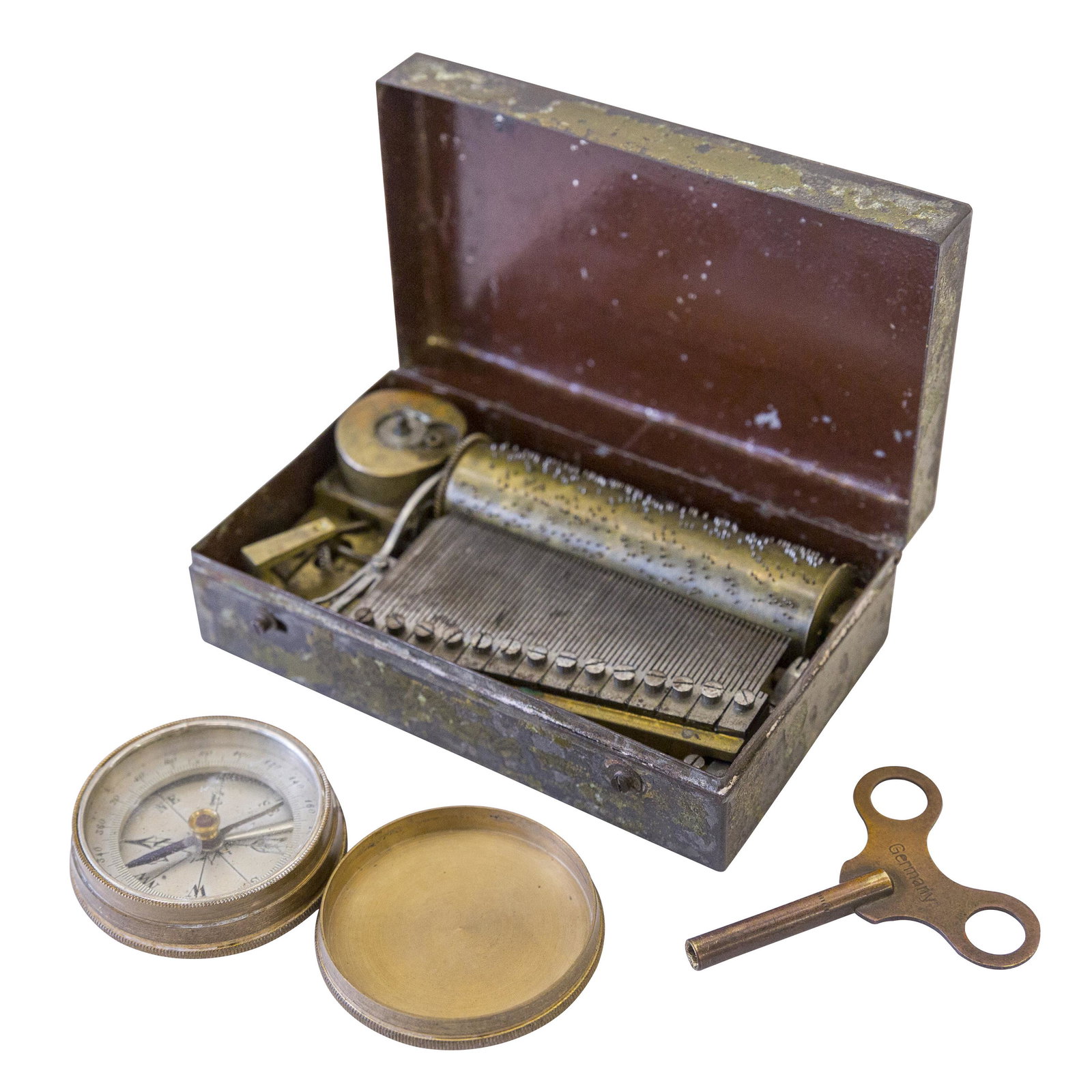 Miniature German Crank Music Box: Metal hinged lid case with miniature brass cylinder movement. Brass compass with silvered face. Music box 3.625 x 2.125d x 1h.