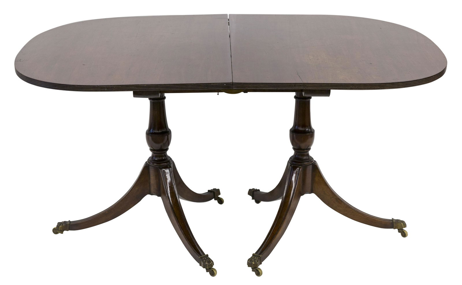 19th Century Mahogany Dining Table: Ribbed border elliptical top over double pedestal Duncan Phyfe style base with brass paw feet and castors. 60w x 42d x 29.5h