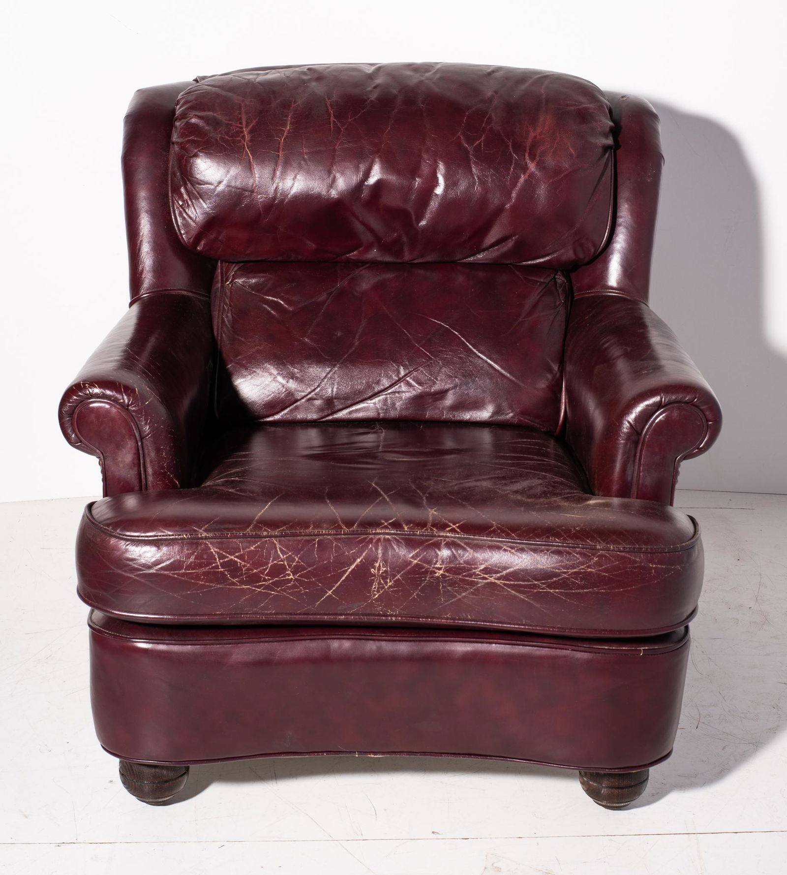 Hancock & Moore Burgundy Lounge Chair: Lounge Chair. Curved rolled arm lounge chair with turned legs and brass nail head trim. Chair 33.5w x 37d x 32.5h Seat height 17.5h