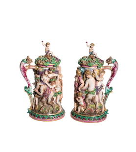 Large Capodimonte Bacchanal lidded steins: Fine pair of large steins decorated in bacchanal bas relief with grape vine lid and figural thumb rest. Mark with blue underglaze mark 7.5w x 5.75d x 14.5h