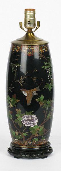 Fine Japanese Cloisonne Vase: Converted to lamp, circa 1910, barrel form with birds, butterfly and branching flowers on background, mounted on carved ebony base Size: vase 5.25d x 12h, lamp 26.75h