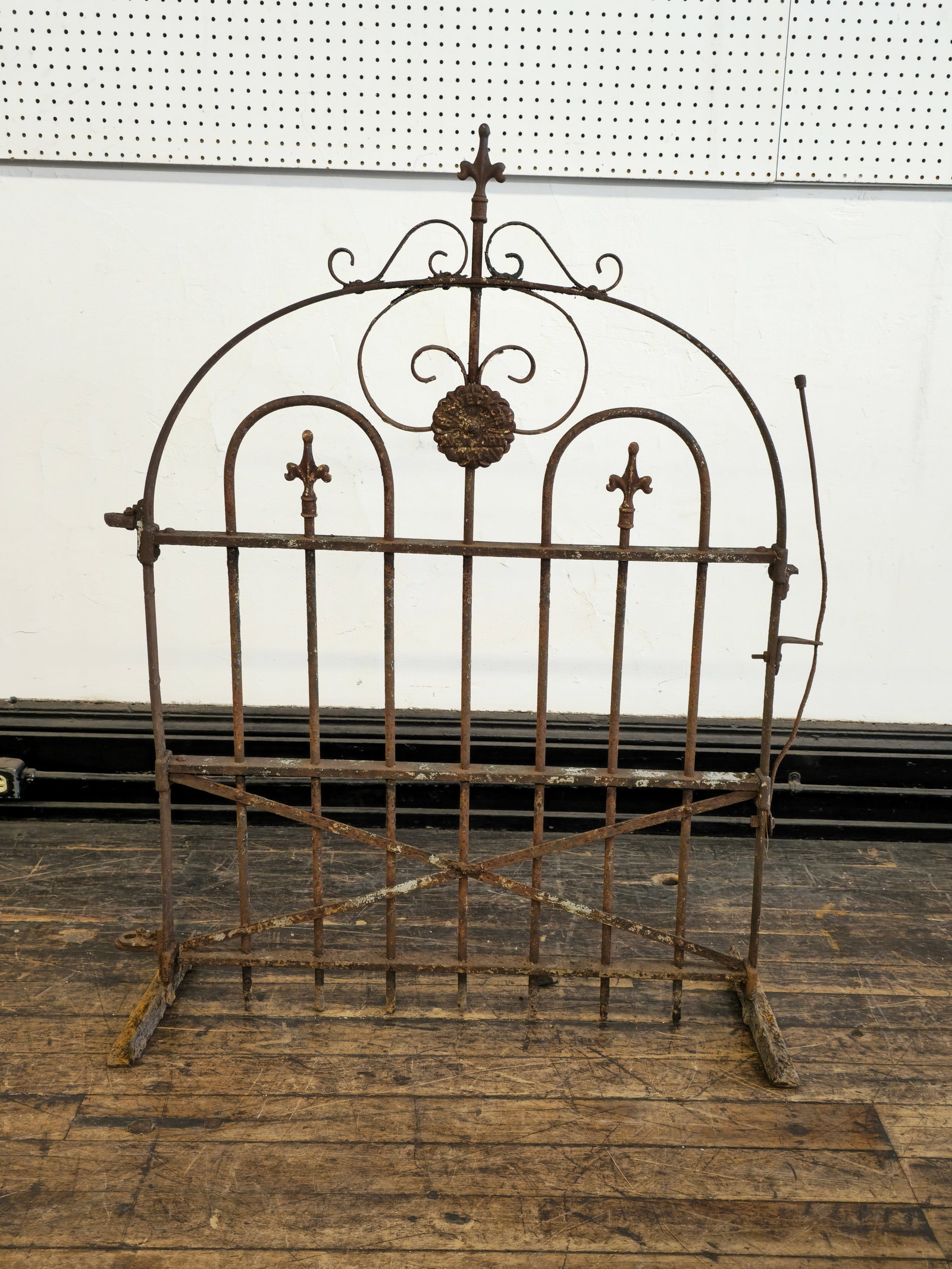Stewart Iron Work Gate: Stewart Iron Work Gate. Circa 1930s. Arched top and welded bracket feet.34 1/2w x 10 1/2d x 46 1/2h. Manufacturer's mark to front.