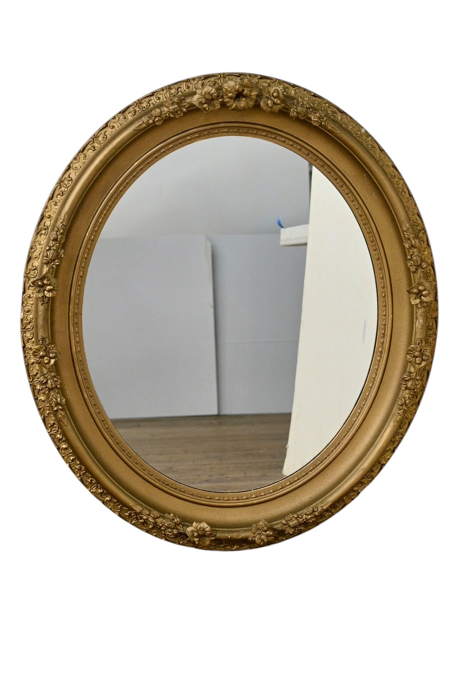 1920s Gold Gesso Carved Oval Mirror+B58: 1920s Gold Gesso Carved Oval Mirror. Molded raised holly leaf exterior border. Interior molded border has high relief raised flowers, leaves and berries. 33 1/2w x 5d x 38 1/2h.
