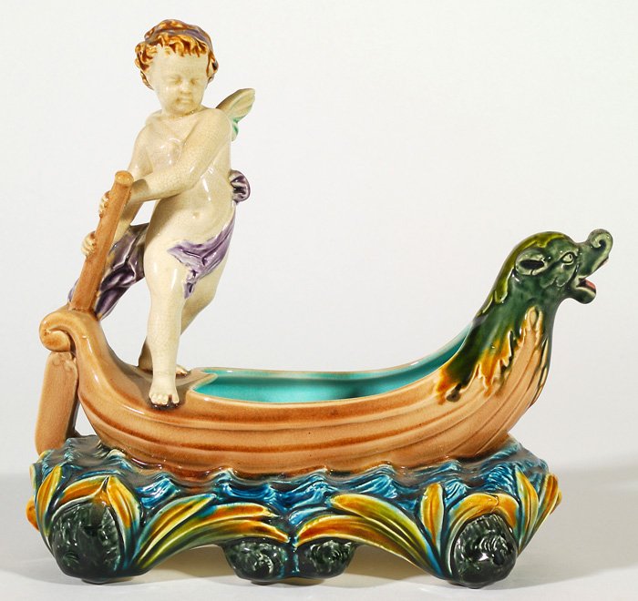 Rorstrand: Ceramic Cherub with oar, standing on boat, great color and detail. Manufacturers mark to underside. Size 10L x 4.75W 9.5H.