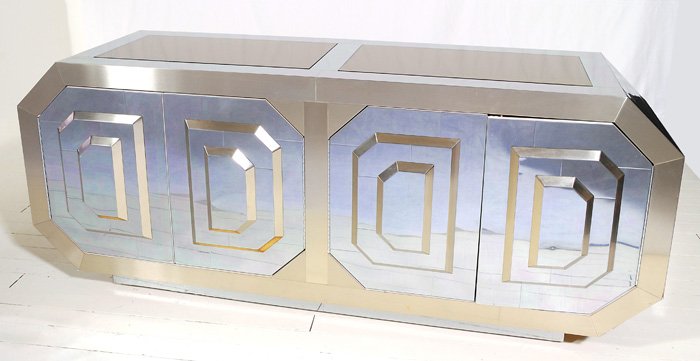 Karl Springer attribution: Unusual chrome, brass and mirrored credenza. Three dimensional geometric pattern doors, angular sides, laminate interior.