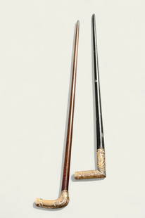 19th Century Gold Filled Walking Sticks: Two canes, circa 1880. Each has gold filled tops with hand chase floral repousse and floral over a scaled ground. Canse are ebony and maple. Maple - 35 3/4" long. Ebony is 33" long.