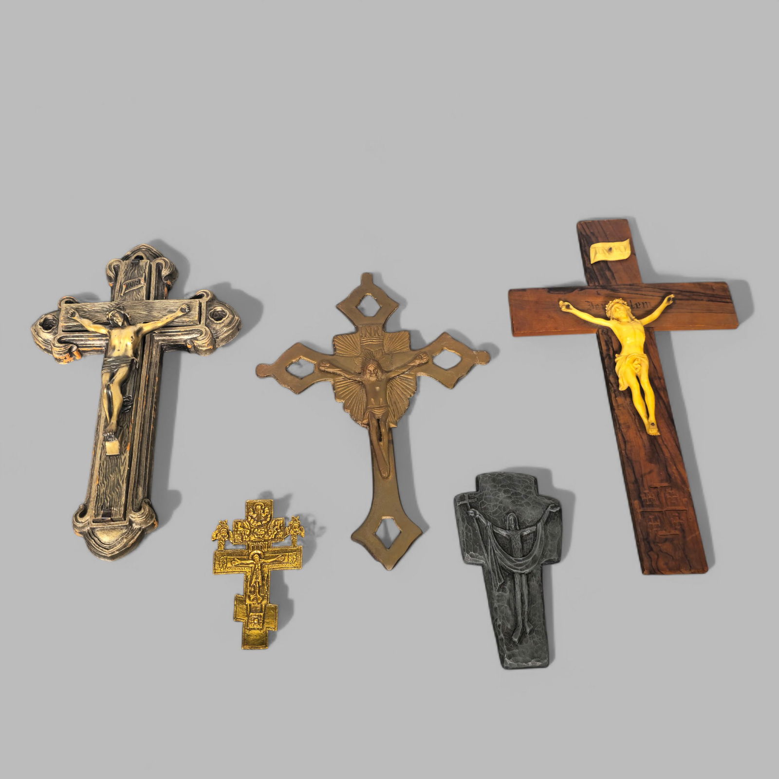 Assembled Crucifixes: Assembled Crucifixes, (5) total, (2) pewter, (1) is Greek and gilt brass, (1) gilt metal and gilt bronze Jesus on an exotic wood cross. Largest- 7 1/4w x 1d x 12 3/4h.