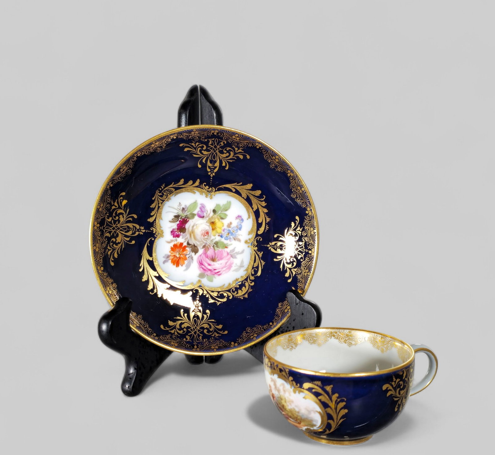 19th Century Crossed Swords Cup and Saucer: 19th Century Crossed Swords Cup and Saucer. Cobalt blue ground with gilt border / and decoration. Hand painted floral interior. Manufacturer's marks to underside. Circa 1880. Saucer 5 1/2 Dia.