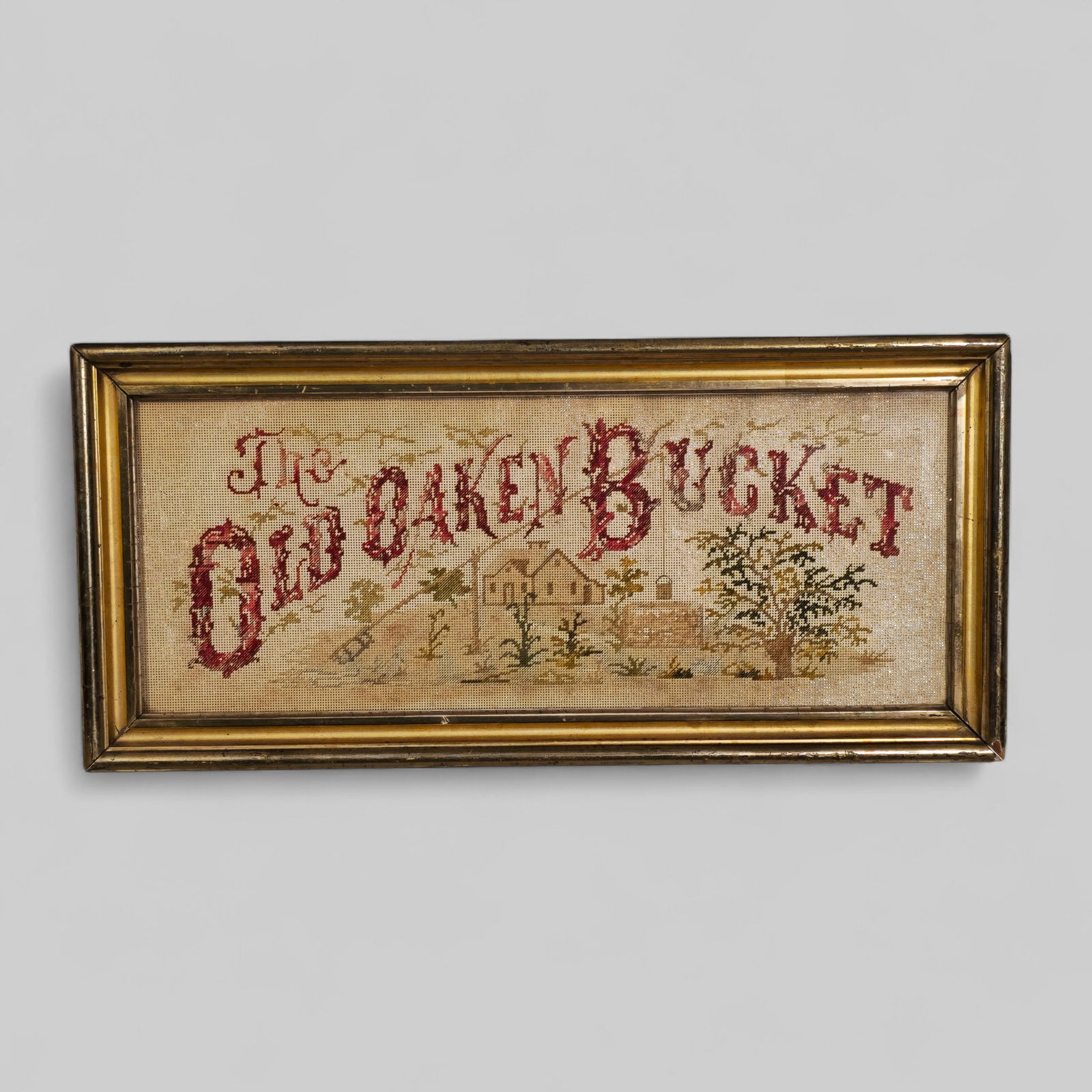 19th Century Sampler "The Old Oaken Bucket": 19th Century Sampler "The Old Oaken Bucket" . Circa 1890. Country house with landscaped pastures. Housed in gilt molded frame. Sampler - 8 x 20 1/2. Frame - 11 x 23 1/4.
