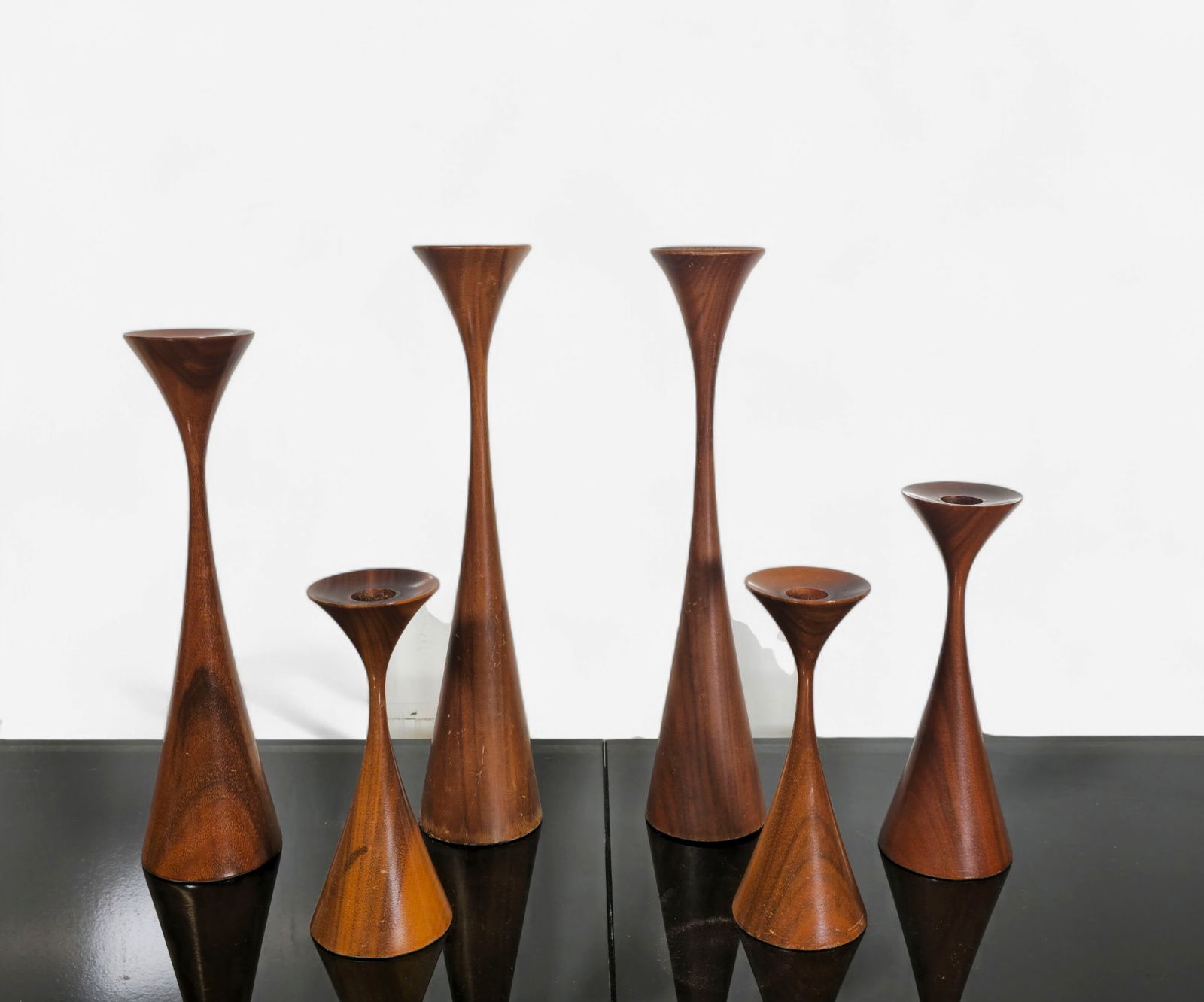 Rude Osolnik candlesticks: .Candlesticks. Set of (6) total. Mid century modern trumpet form or hourglass walnut candlesticks by Rude Osolnik. Original green felt bases stamped with Osolnik hallmark. Rude Osolnik went to Berea C