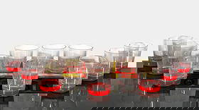 Michael and Frances Higgins Tray & MCM Tumblers: Mid-century modern glass service set by Michael and Frances Higgins, including a fused glass tray and twelve ribbed tumblers. The tray features alternating red and yellow squares with abstract enamel