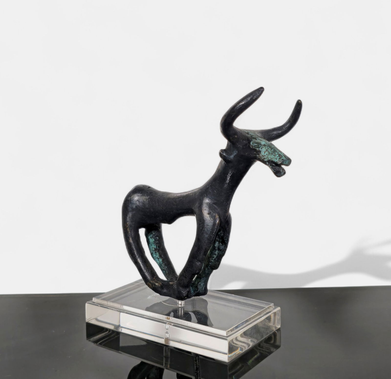 Brutalist Bronze Bull Sculpture: Mid century modern abstract cast bronze bull rendered in a bold Brutalist style, featuring angular limbs, openwork body, and pronounced horns. The dark patinated surface with green verdigris highlight