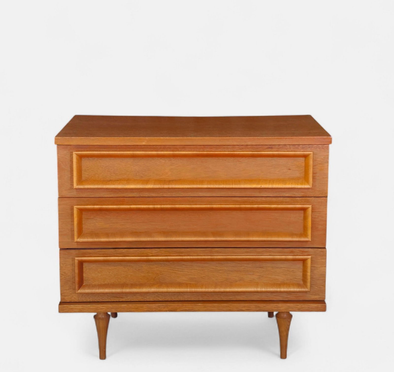 Mid-Century Modern Three-Drawer Dresser/ Chest: Mid-Century Modern chest featuring three full-width drawers with distinctive raised, mitered panel fronts and tapered turned legs. Constructed of richly grained walnut-tone wood with a warm satin fini