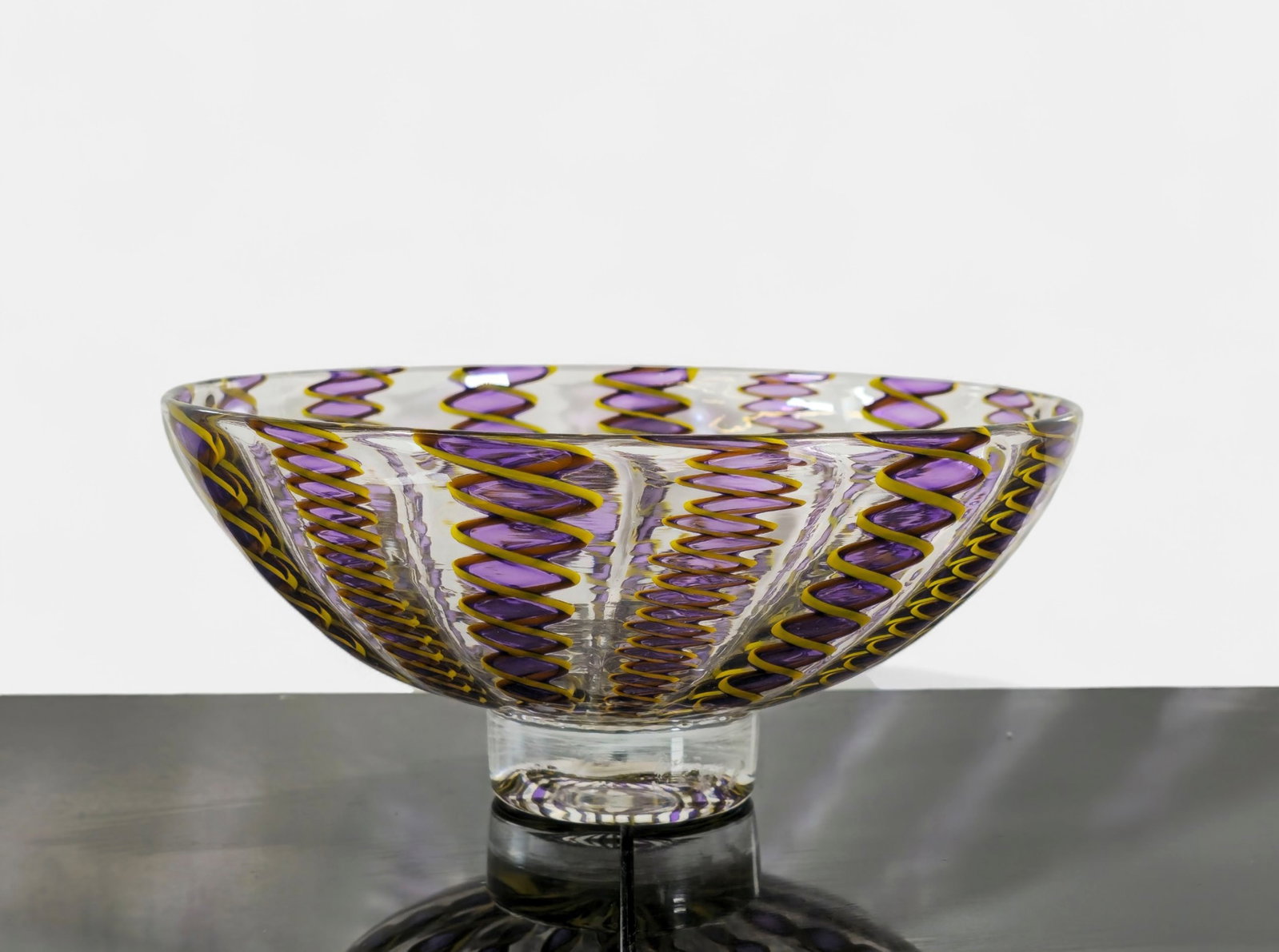 Murano Zanfirico Art Glass Bowl: Murano art glass bowl in the Zanfirico, featuring twisted ribbon canes of purple and gold encased in clear glass. Raised on a short circular foot with polished pontil. Finely crafted with even pattern