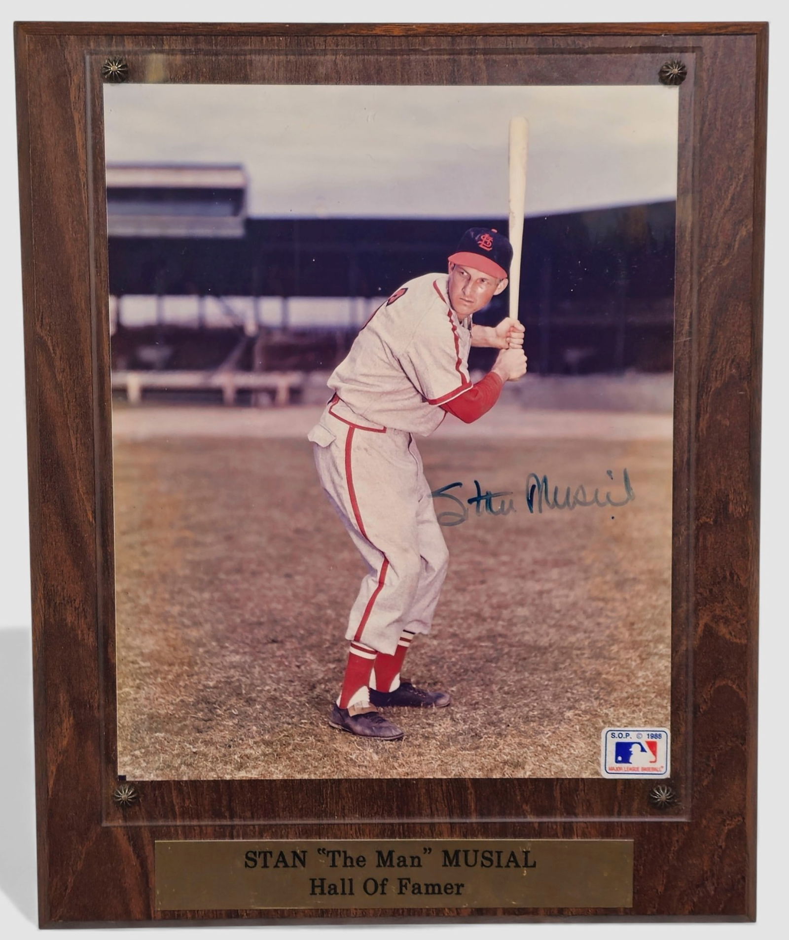 Stan “The Man" Musial – Hall of Famer autographed photographic plaque: Autographed color photographic plaque depicting legendary St. Louis Cardinals outfielder Stan Musial (1920–2013, USA) in batting stance on the field. Signature appears boldly across the lower right