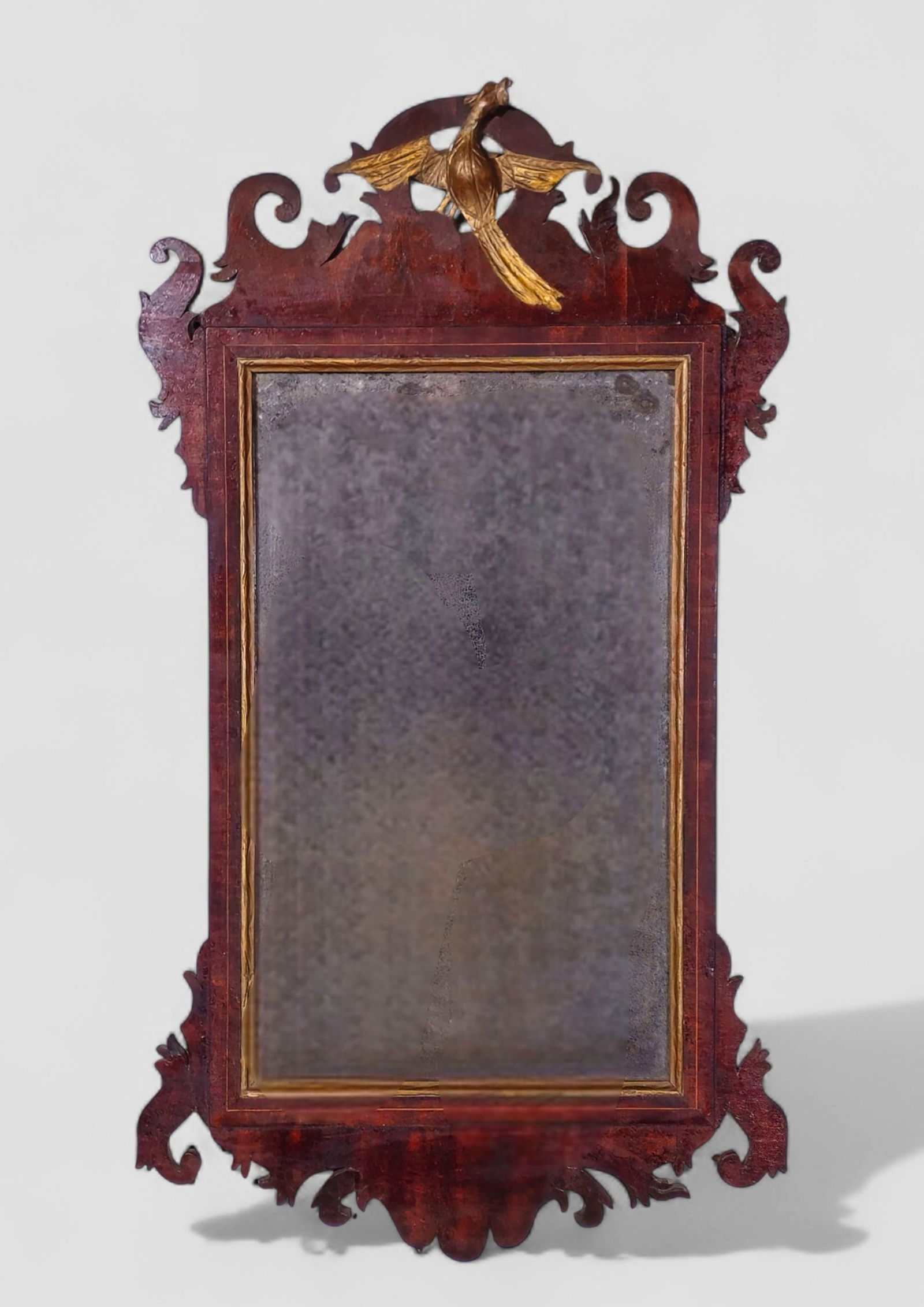 18th Century Georgian Mahogany Inlaid Mirror: 18th Century Georgian Mahogany Inlaid Mirror. 1770-1790. Elaborate fret work mahogany frame with maple string inlay. Gilded phoenix to center. 19 3/4w x 2d x 35 1/2h.