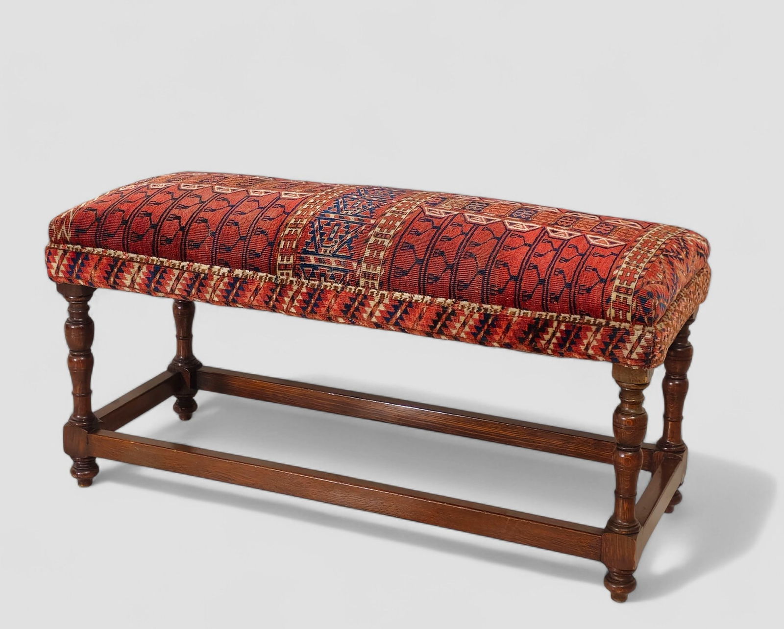19th Century William & Mary Style Tekke Rug Upholstered Bench: 19th Century William & Mary Style Tekke Rug Upholstered Bench. Circa 1880-18900. Oak turned legs, box stretchers and bun feet. 40w x 16d x 20h.