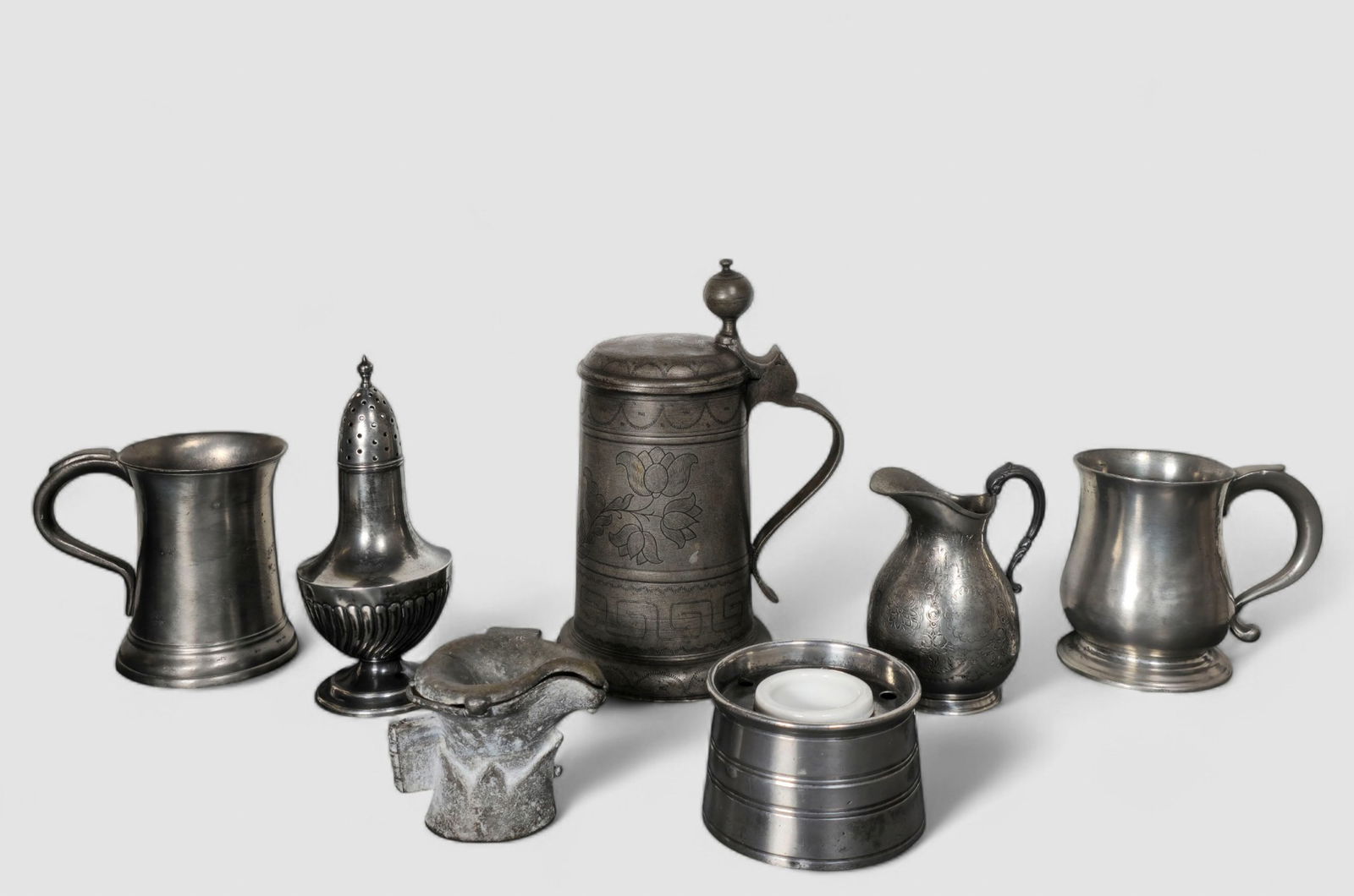 Assembled 18th and 19th Century Pewter: Assembled 18th and 19th Century Pewter. 7 pieces total. 2 tankards, dutch covered. Dated 1770, incised tulips. 9 1/4 h. Inkwell with insert, chocolate mold, cream pitcher and muffineer, "SB & M"