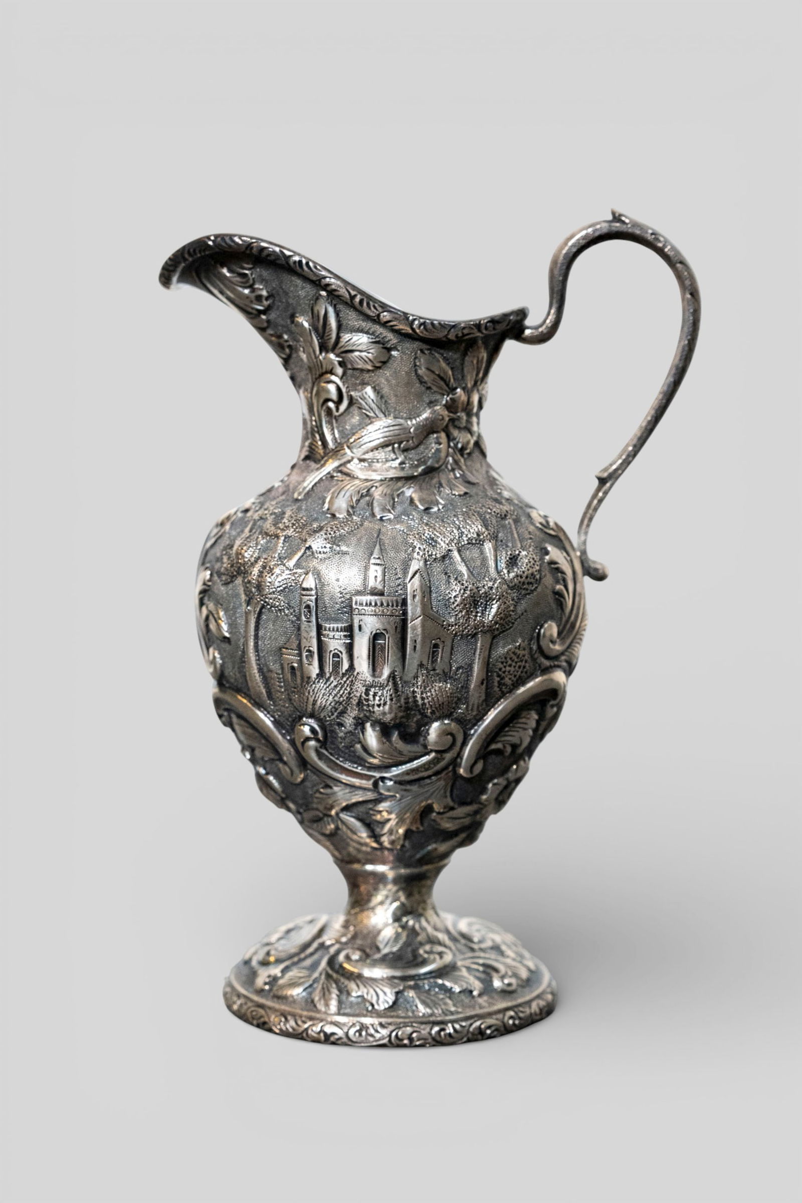 Loring Andrews Sterling Silver Castle Pattern Creamer, #190: Loring Andrews Sterling Silver Castle Pattern Creamer, #190. Repousse design with castle, flowers, scrolls, and landscapes. Manufacturer's marks to underside, sterling and #190. 4w x 3d x 6 1/4h.