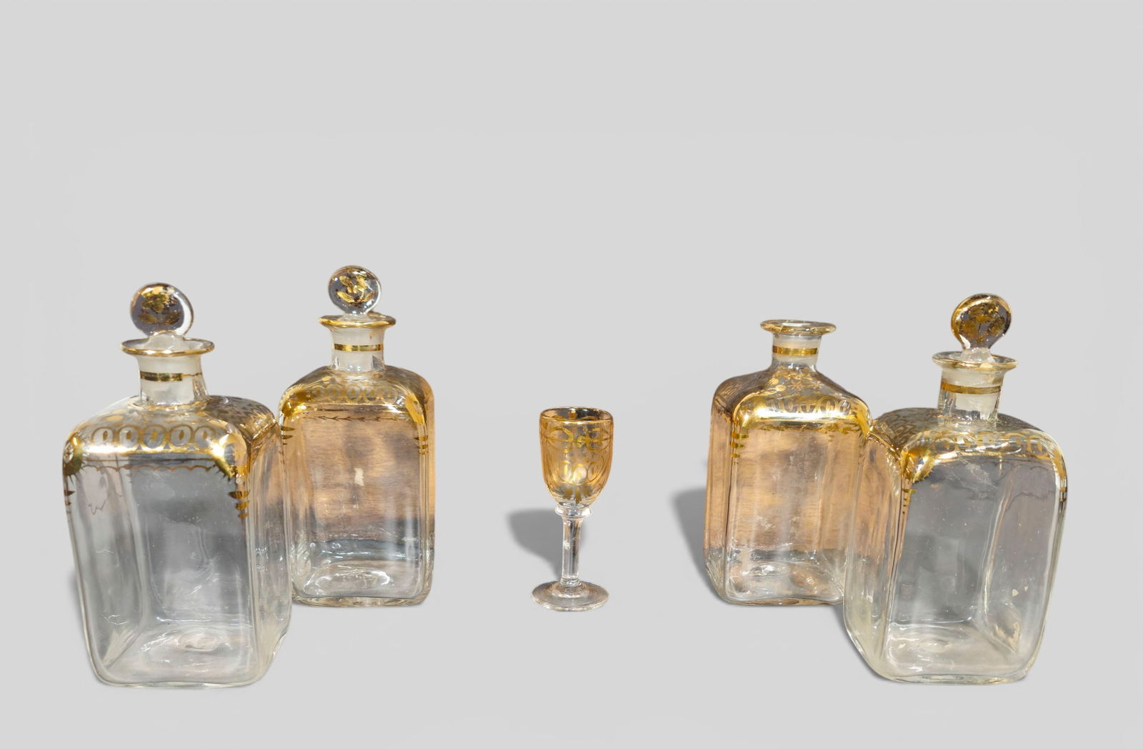 18th Century Liquor Set: 18th Century Liquor Set. Circa 1760. Wood box, original 4 liquors bottles with gilt decoration and stoppers. Liquor 2 5/8w x 2 5/8d x 6h. Cordial - 3 5/8h. Box 6 3/4w x 6 3/4d.