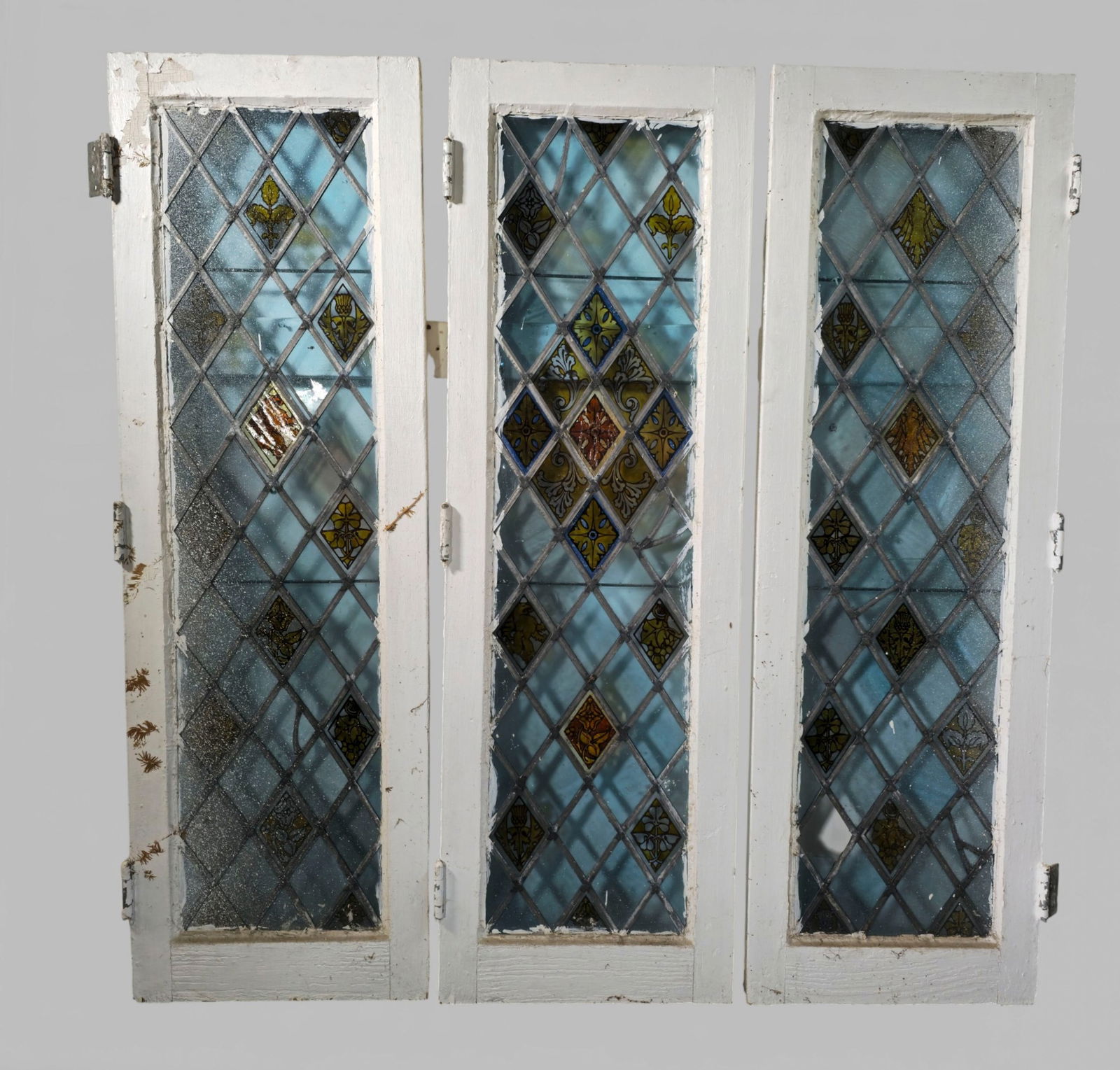 Art Nouveau Stained & Leaded Glass Floral Diamond Shaped Windows: Art Nouveau Stained & Leaded Glass Floral Diamond Shaped Windows. Pair. Circa 1910. Painted wood frames. 16 1/4w x 1 1/2d x 51 3/4h.