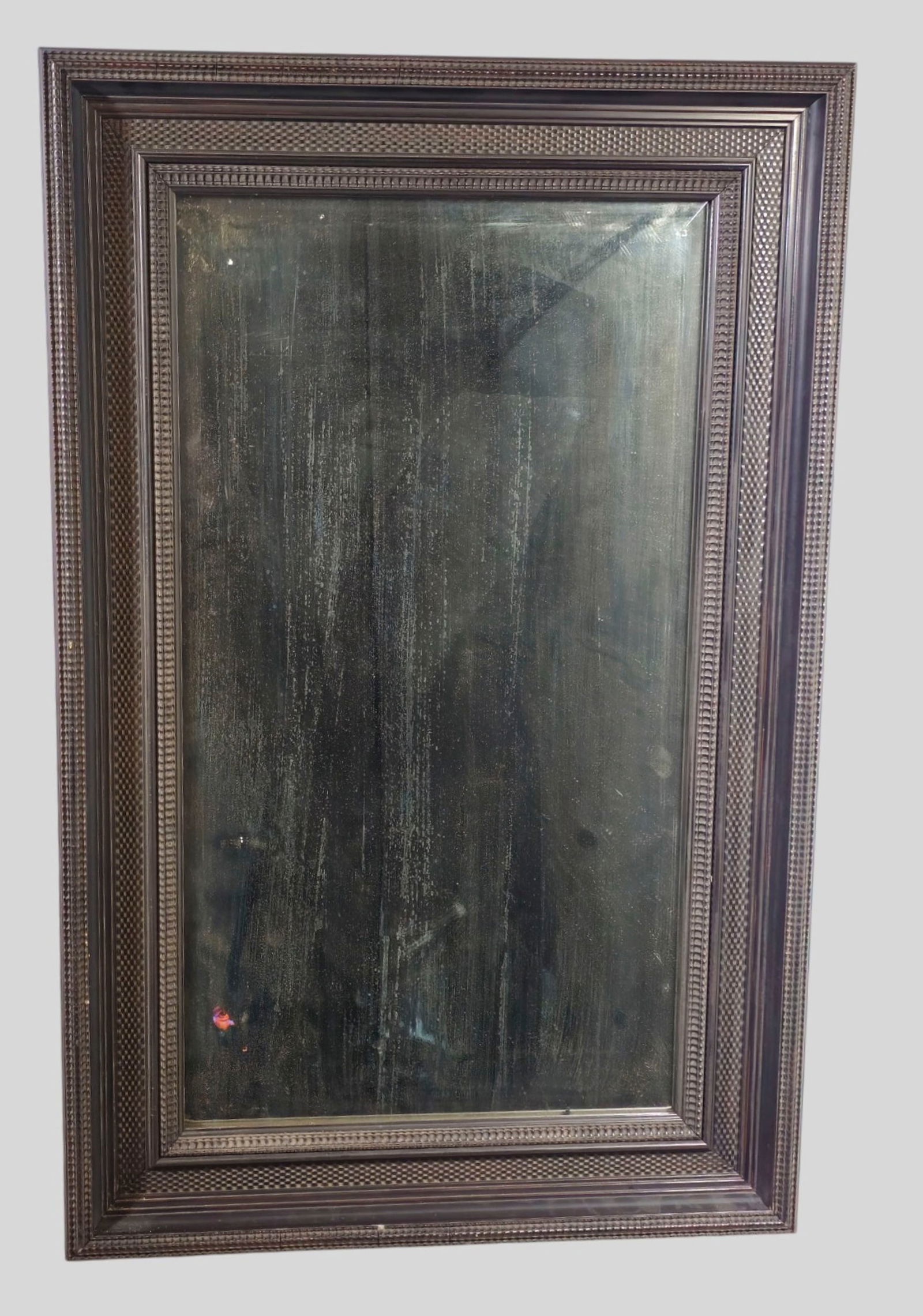 Carved Ebony Mirror: Carved Ebony Mirror. 20th Century cove molded exterior frame. Quilted engraved interior frame. 25 5/8w x 2d x 39 3/4h.