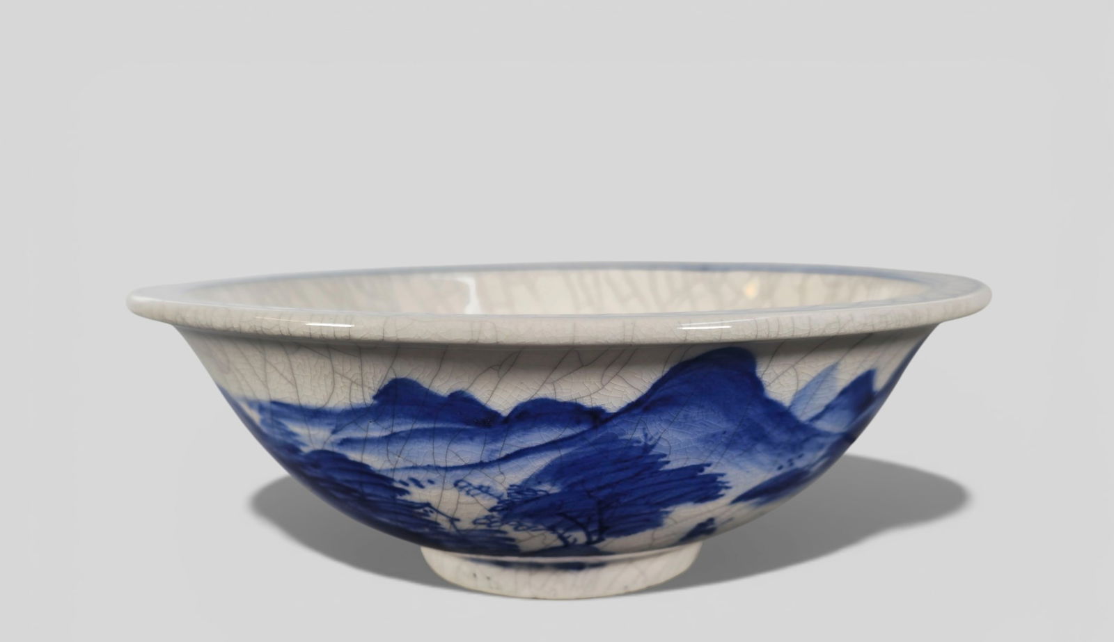 Chinese Kangxi Period Crackle‑Glazed Blue & White Landscape Footed Bowl: Chinese Kangxi Period Crackle‑Glazed Blue & White Landscape Footed Bowl. Refined blue and white porcelain footed bowl dating to the Kangxi period, decorated with a crackle‑glazed surface a
