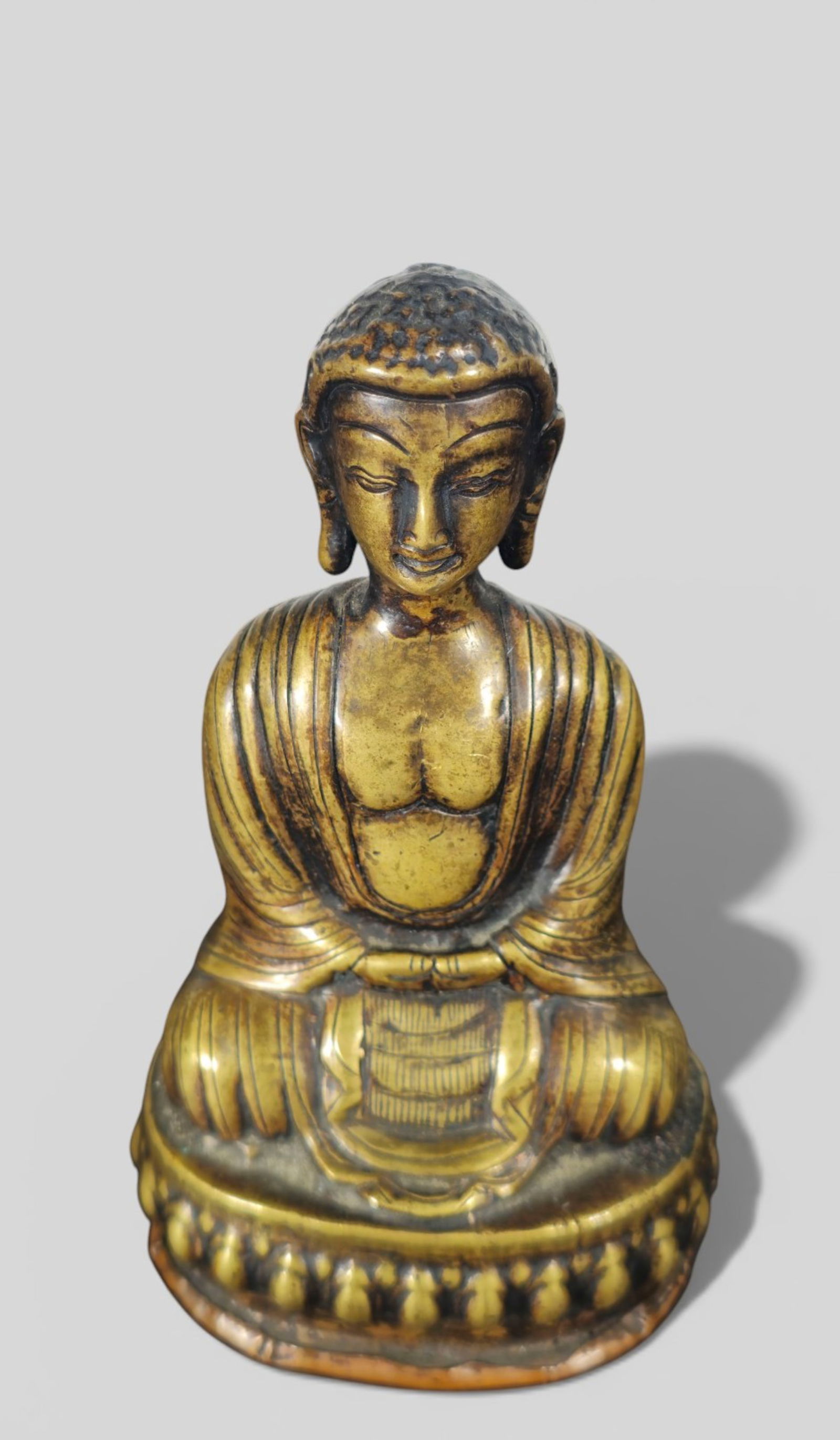 Bronze Figure of Shakyamuni Buddha, Possibly 18th Century: Bronze Figure of Shakyamuni Buddha, Possibly 18th Century. A well‑cast bronze figure of Shakyamuni Buddha seated in dhyāna on a double‑lotus base, the hands in bhūmisparśa m