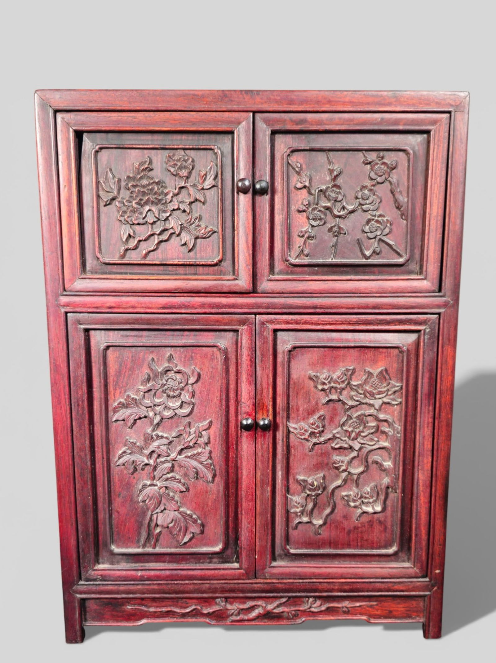 Chinese Rosewood Carved Floral Tea Cabinet: Chinese Rosewood Carved Floral Tea Cabinet. A Chinese rosewood tea cabinet is finely carved with floral motifs, displaying traditional joinery and a warm natural patina. Compact form likely intended f